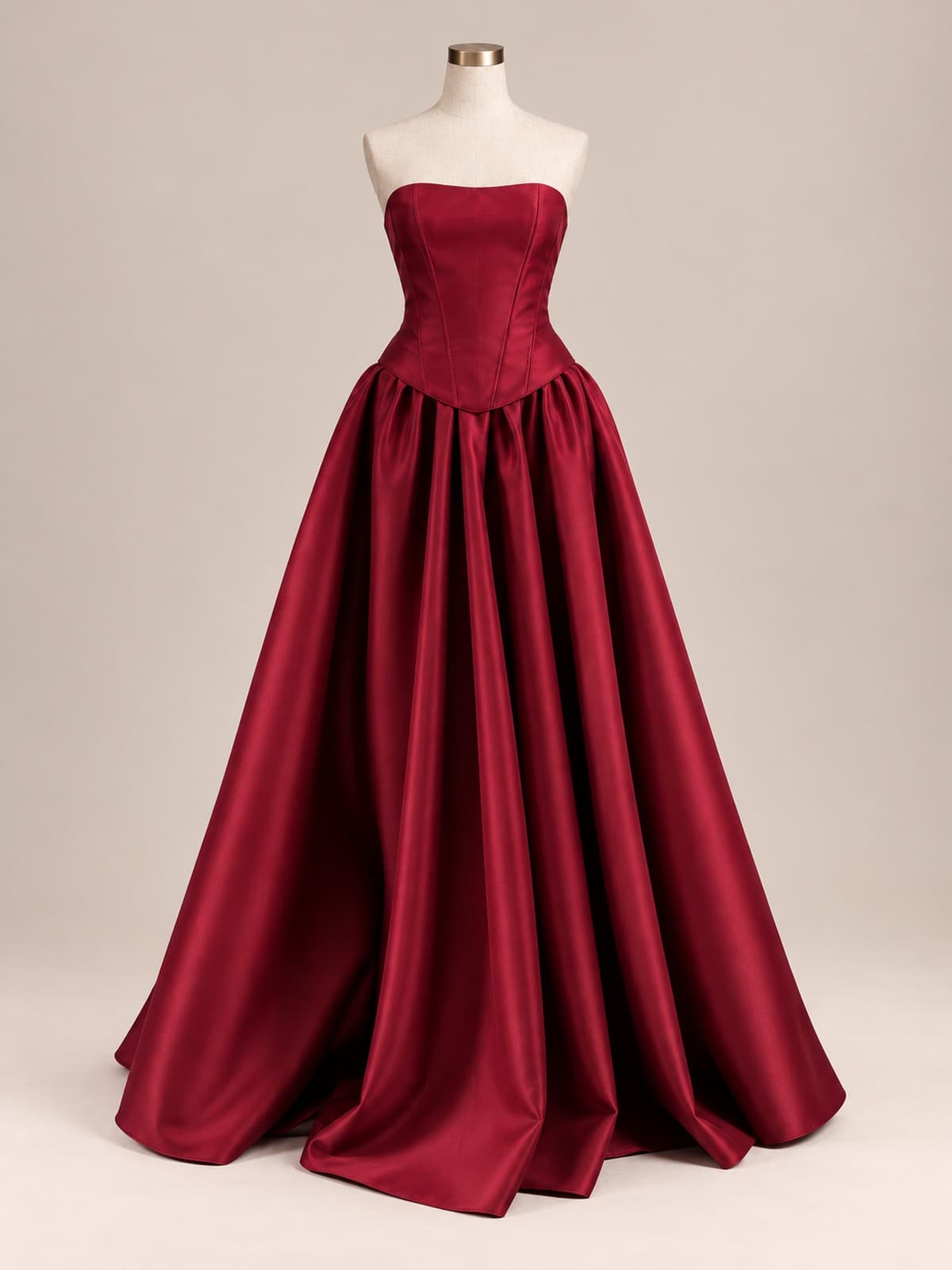 Vestido de festa Rubi: cetim bordô, tomara-que-caia de corpete estruturado com barbatanas e saia ampla franzida até o chão, em manequim de ateliê.
